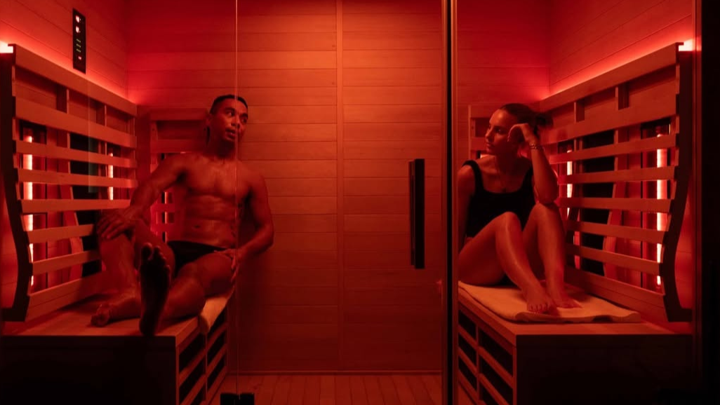 Two people in a infrared sauna with red lighting